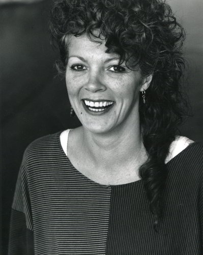 Handspan Theatre Trish Simmons laughing woman with hair piled up loosely wearing a knitted jumper