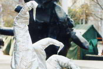 three tall crushed silver cones one bends, one bows, one kneels