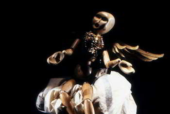 winged wooden figure floats on a cloud, gazing at a star